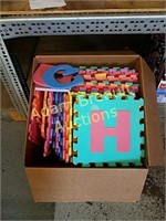 Box of foam floor mat with letters