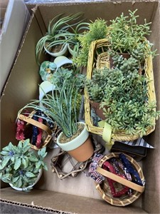 A box with smal faux plants and tiny baskets, a