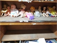 Shelf lot with different size dressed dolls