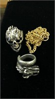 One unmarked silver tone skull ring and one