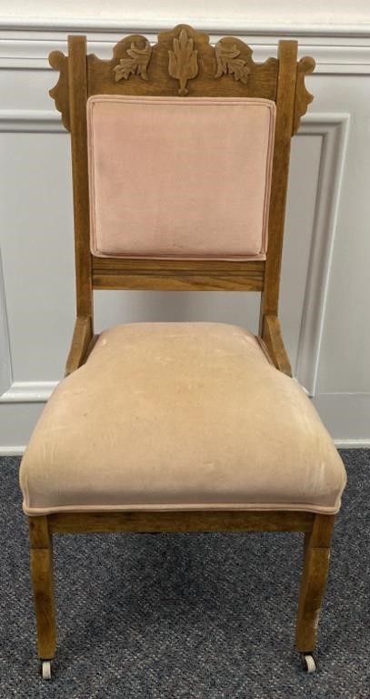 Antique Eastlake style padded chair with casters