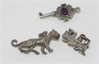 Three silver charms - train, lion and key