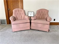 Two light-colored upholstered swivel chairs