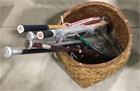 Woven basket full of tennis rackets and bats