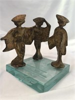Metal figures on glass pedestal