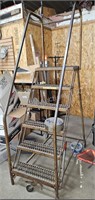 Rolling warehouse ladder with hand rails and platf