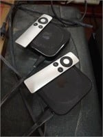 Pair of Apple Tv with remotes and cords