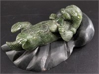 Alaskan jade carving of an otter set on dark stone