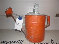 red metal watering can