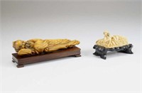 TWO IVORY CARVED RECLINING FIGURES ON STAND