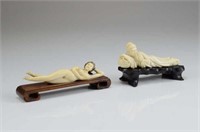 TWO IVORY CARVED RECLINING FIGURES ON STAND