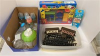 Box of baby bottles and nipples, plastic trains