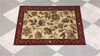 Red and tan rug with floral design