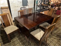 Drop leaf table with 6 chairs. Has pads and 1 leaf