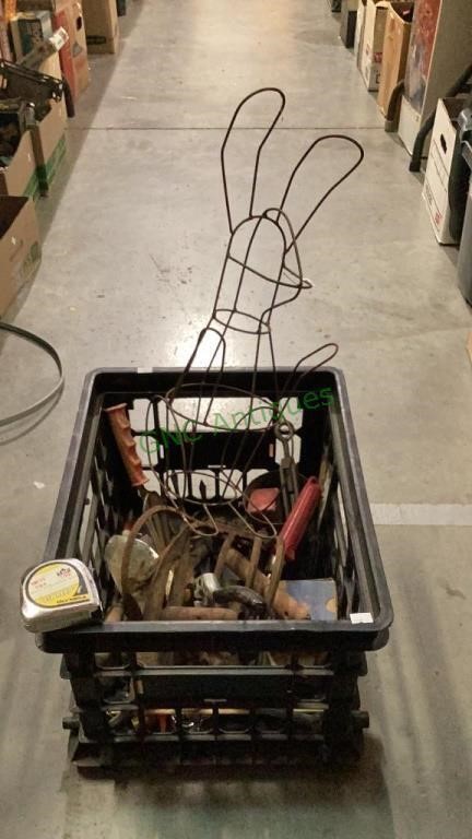 Plastic crate full of yard tools includes a tape