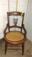 Cane bottom dining chair with arms
