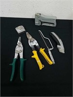 Swingline stapler, tin snips, a utility knife and