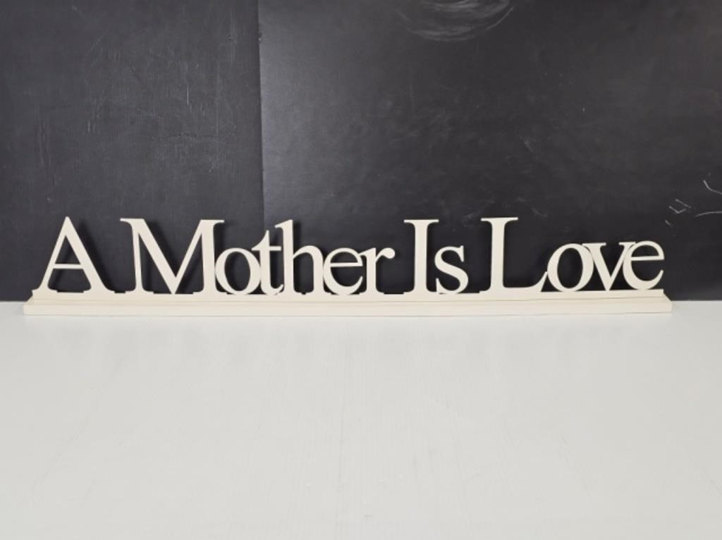 A MOTHERS LOVE METAL SIGN ON WOOD - 34.25" LONG