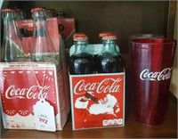 Coca cola bottles and glasses on shelf
