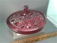 Covered red glass candy dish with ornate pattern
