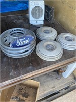 SEVEN VINTAGE HUBCAPS AND A FORD EMBLEM