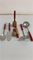 Seven red handled kid’s kitchen utensils