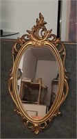 Oval mirror with ornate gold frame 16 in by 30 in