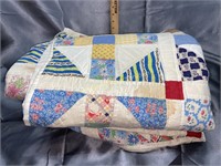 Old hand made quilt has some stains and wear