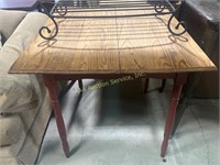 Wood family table with red painted legs, worn.