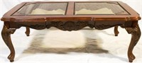 Heavily carved coffee table w/ inset glass