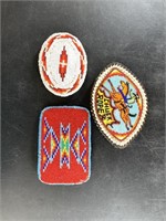 Three intricately beaded belt buckles in Native Am