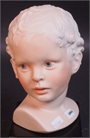 A Cybis bust of a child on black base, 9 1/2" high