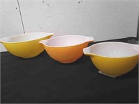 Three out of four vintage Pyrex orange and yellow
