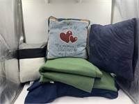 Assortment of fleece blankets and throw pillows