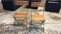 2 wood and metal folding chairs