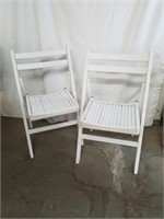 Two white wood fold-up chairs