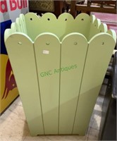 Large light green trash can or umbrella stand.