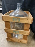 Glass water jug in crate.