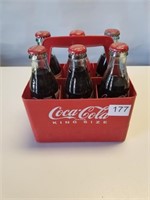Various Coca Cola Bottles in Plastic Carrier