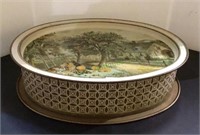 Oval vintage tin with cottage scene measuring 4