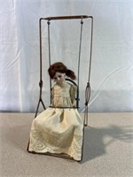 Vintage doll with metal swing