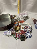 Tin with patches, keychains and belt buckles