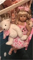 Doll and bear in pink chair