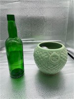 green glass bottle and ceramic planter