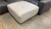 Smooth Leather Tufted Oatmeal Colored Ottoman.