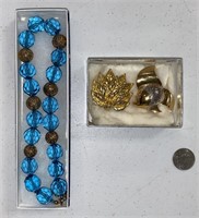 CRYSTAL BEAD NECKLACE & TWO SIGNED BROOCHES.