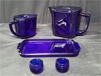 Set of cobalt blue glass lidded pitchers, tray, &