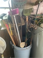 Plastic trashcan full of garden tools