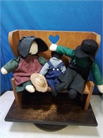 Group of 3 faceless rag dolls on a wooden bench