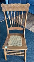 Oak chair with nice carving on back, wicker seat
